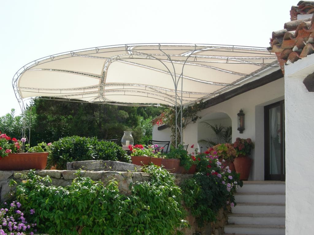 Villa con fiori e struttura curva ombreggiante su terrazza con scalinata